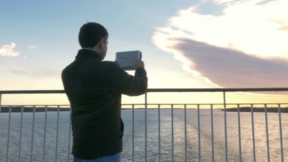 Man Using Pad To Make Scenic Photos From The Ship