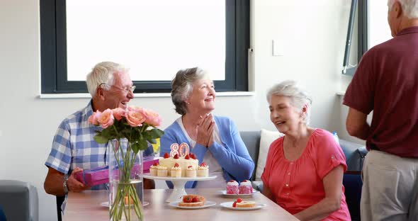 Senior woman receiving gift from her friend