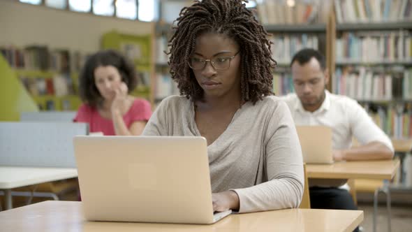 Front View of Serious African American Woman Using Laptop