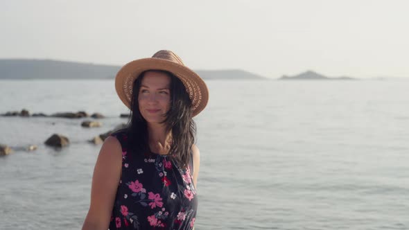 Closeup of a Girl in a Hat Smiling Walking By the Sea