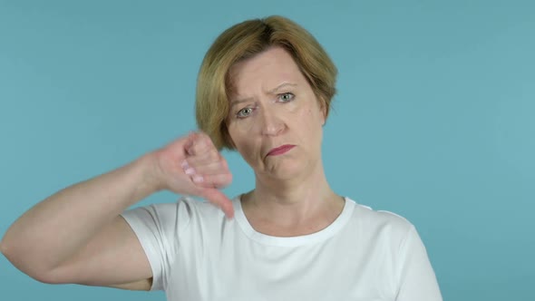 Old Woman Gesturing Thumbs Up Isolated on Blue Background