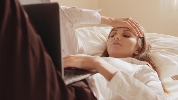 Woman Suffering From Headache While Using Laptop on Bed