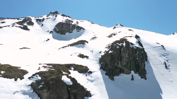 Aerial lowering of a very skilled sportsman skiing down a snow covered steep slope at Piltriquitron