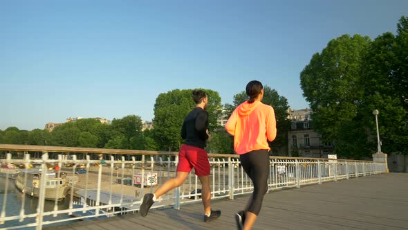 A couple running across a bridge