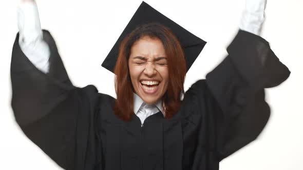 Happy African American Female Student in Academic Dress Passing Graduate Exam and Rejoicing Over