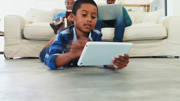 Boy using digital tablet in living room