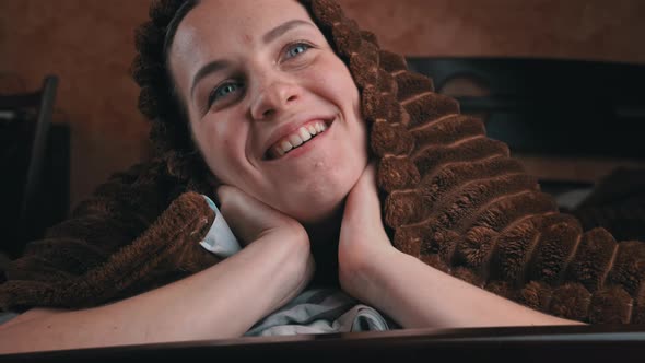 Girl Lying on Bed Watches TV and Switches Channels with Remote Control Closeup