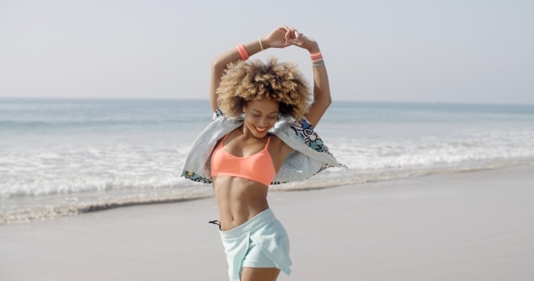 Girl Jumping With Joy On The Seashore