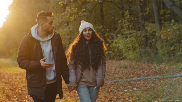 Happy Young Couple in Love Walking in Autumn Park at Sunset Romantic Evening Date in Nature Excited