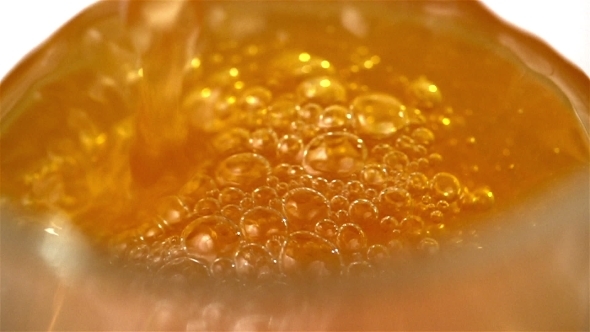 Orange Soda Pouring With Bubbles Into Glass