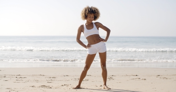Woman Practices Yoga On A Beach