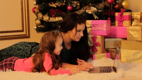 Mother And Daughter Passing Time With Laptop