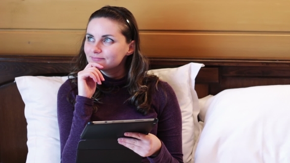 Happy Woman With The Tablet On The Bed