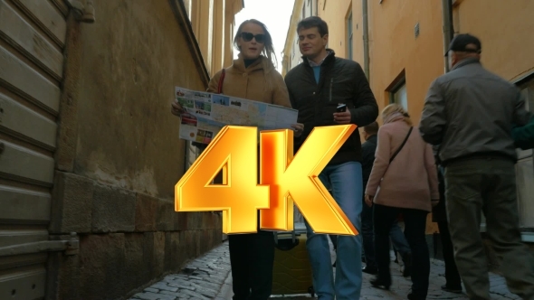 Tourists Walking Around The City Holding A Map