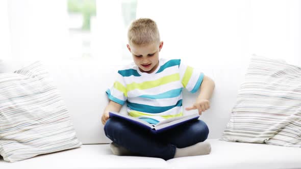 Smiling Little Schoolboy Reading Book At Home 2