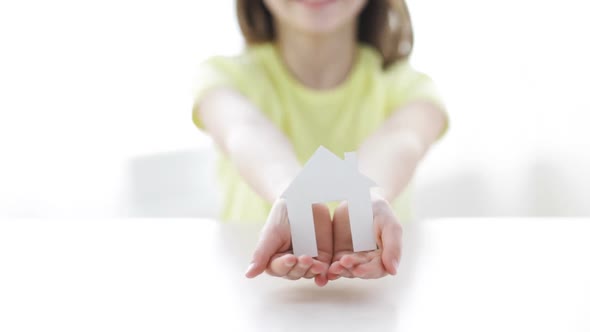 Close-Up Of Smiling Girl Holding Paper House 1