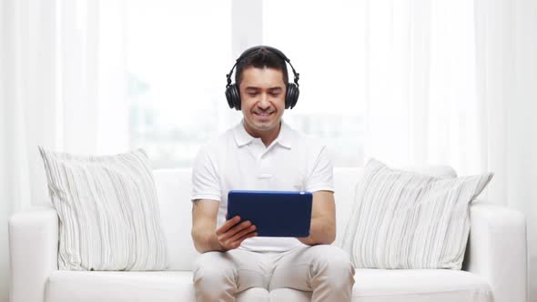Smiling Man With Tablet Pc And Headphones At Home 1