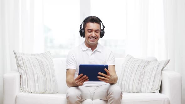 Smiling Man With Tablet Pc And Headphones At Home 2