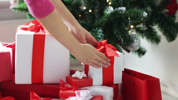 Woman Putting Present Under Christmas Tree 1