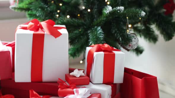 Woman Putting Present Under Christmas Tree 2