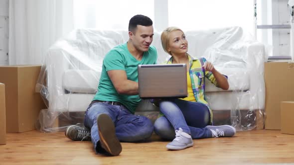 Couple With Laptop Sitting On Floor In New House 1