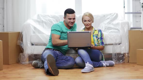 Couple With Laptop Sitting On Floor In New House 2