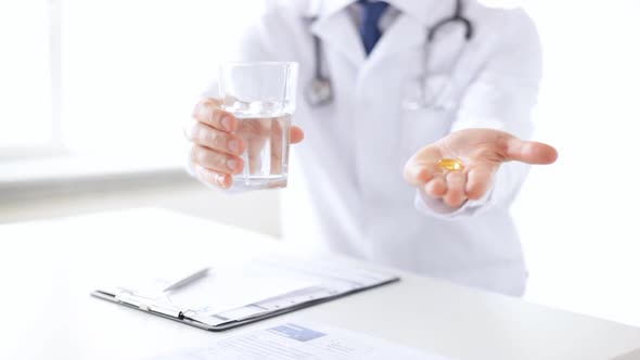 Male Doctor Hands With Pills And Glass Of Water
