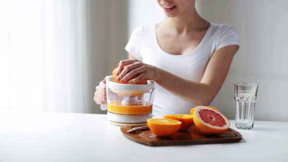 Woman With Squeezer Squeezing Orange Juice At Home 3