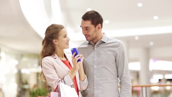 Couple With Smartphone And Shopping Bags In Mall 2