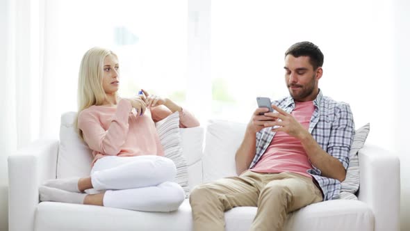 Couple With Smartphones Texting At Home 10