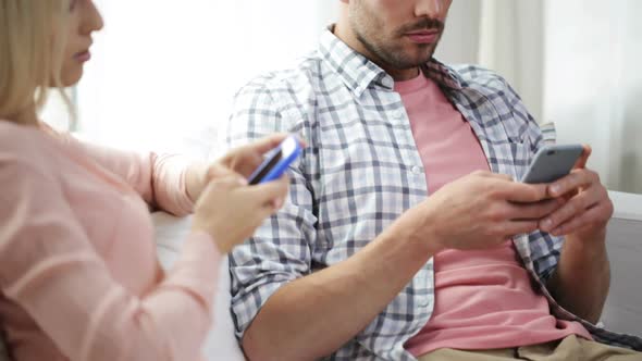 Couple With Smartphones Texting At Home 2