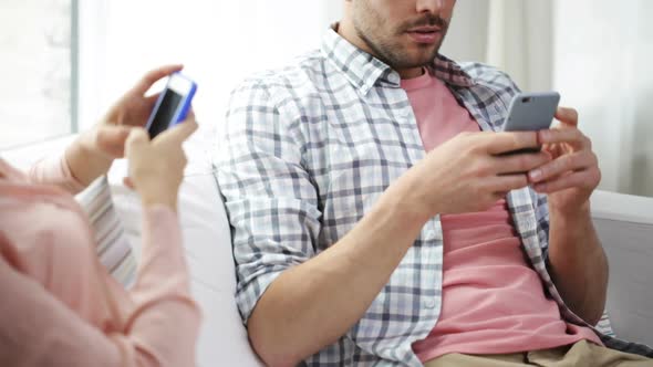 Couple With Smartphones Texting At Home 3