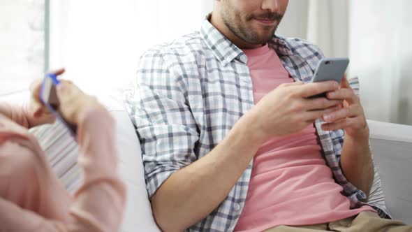 Couple With Smartphones Texting At Home 5