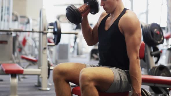 Young Man With Dumbbells In Gym