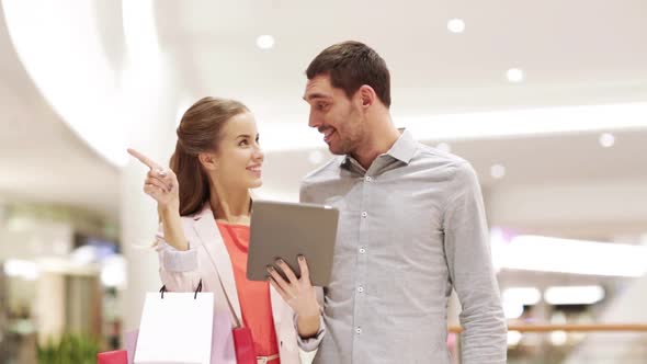 Couple With Tablet Pc And Shopping Bags In Mall 1