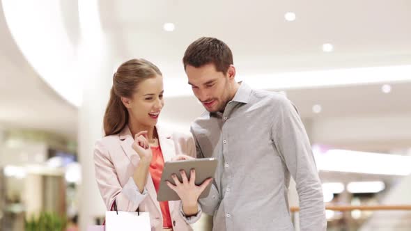 Couple With Tablet Pc And Shopping Bags In Mall 3