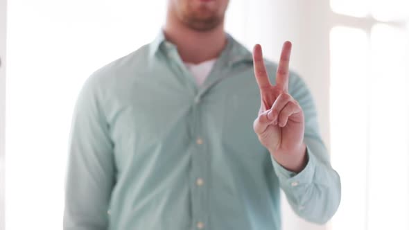 Man In Shirt Showing Sign Of Victory By Hand