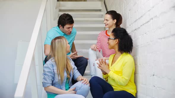 Smiling Students Sitting On Stairs And Talking 2