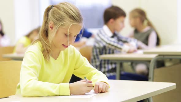 Group Of School Kids Writing Test In Classroom 7 alt