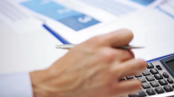 Businessman Hand With Calculator And Papers