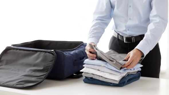 Businessman Packing Clothes Into Travel Bag 1