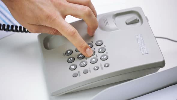 Hands Dialing Number On Desk Set Phone At Office