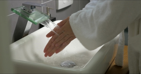 Woman Washing Hands With Soap In The Bathroom