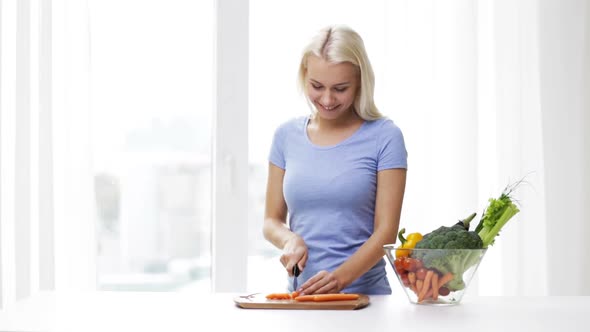 Smiling Young Woman Chopping Vegetables At Home alt