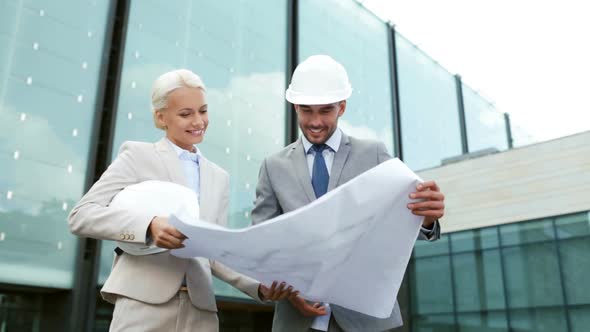 Smiling Businessmen With Blueprint And Helmets 1