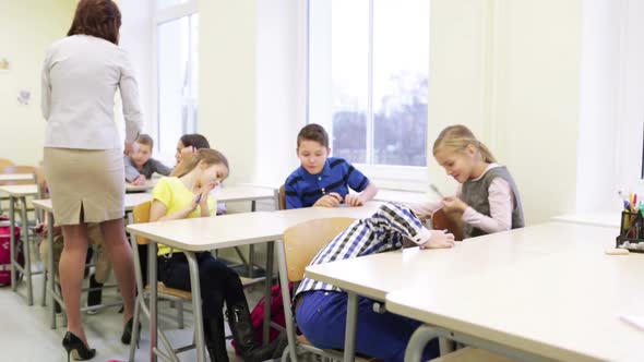 Teacher Giving Pens To School Kids In Classroom 1