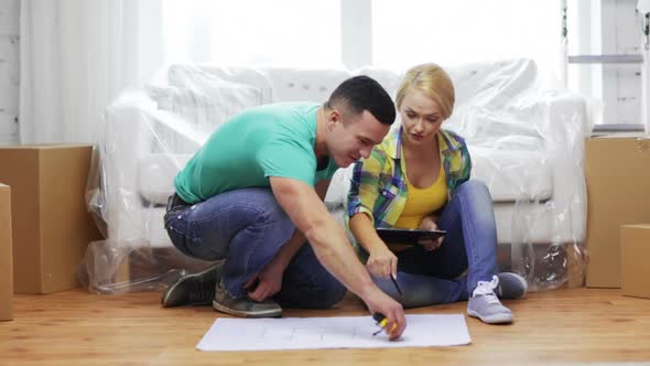 Smiling Couple Looking At Blueprint In New Home 2