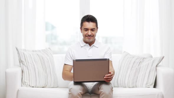 Happy Man Working With Laptop Computer At Home