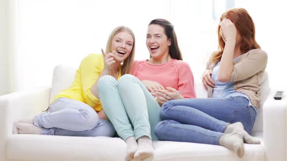 Three Smiling Teenage Girls Watching Tv At Home 1