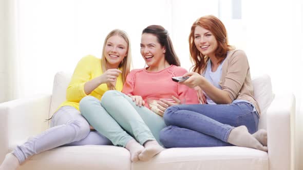 Three Smiling Teenage Girls Watching Tv At Home 3